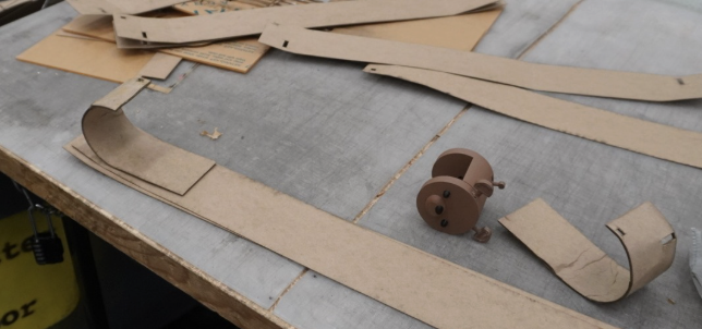 Chipboard bridge prototypes and bear bracket on a workshop table