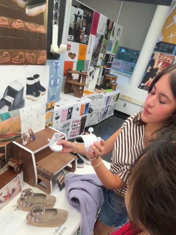 Lillian demonstrating a prototype beside her Industrial Design exhibition display
